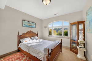 Arched window providing abundant natural light, neutral wall tones, beige carpeting, and crown molding