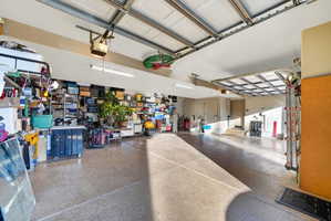 Spacious garage featuring a durable epoxy floor, overhead door, and recessed lighting