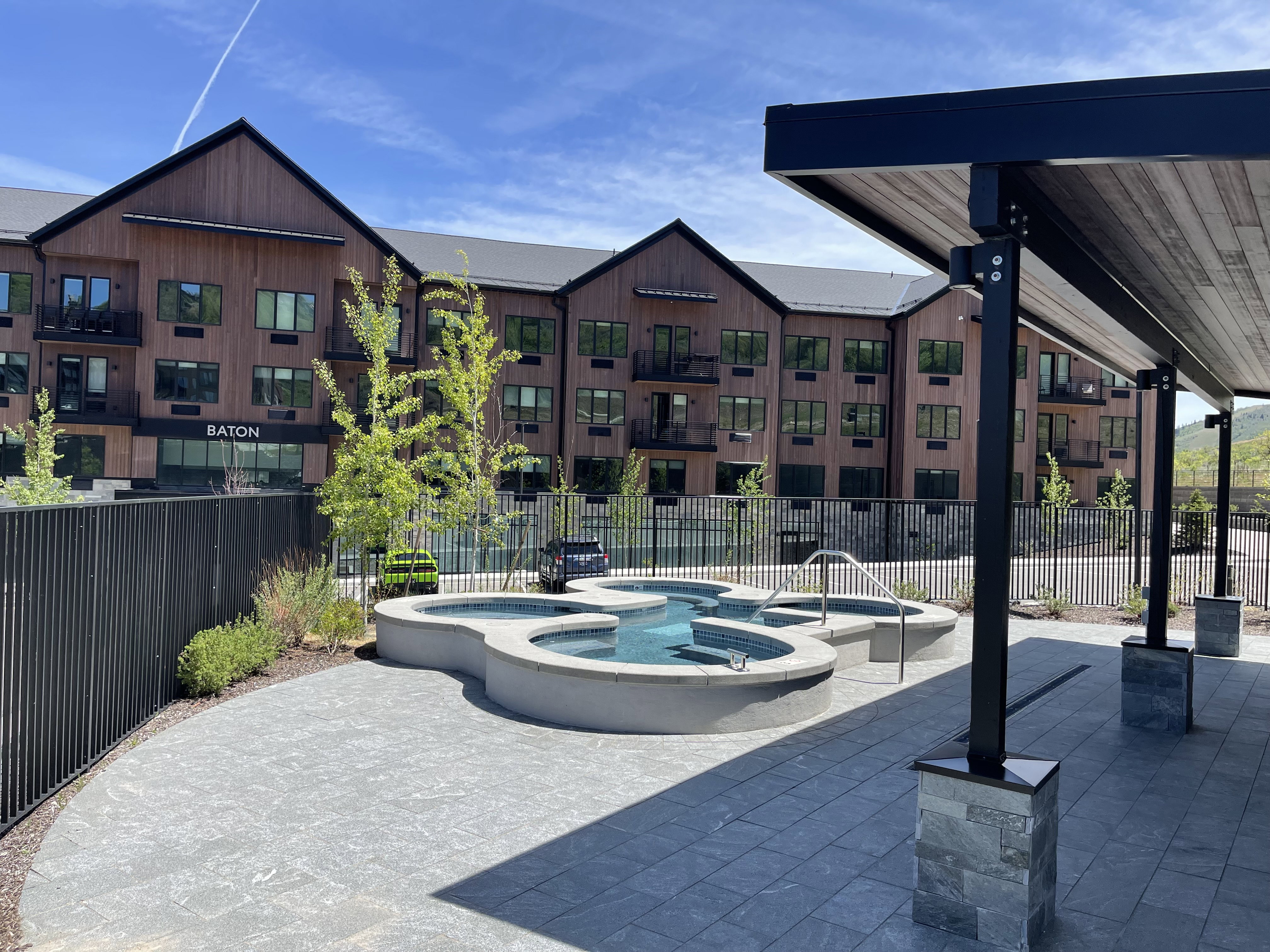 View of property's community with a hot tub and a patio area