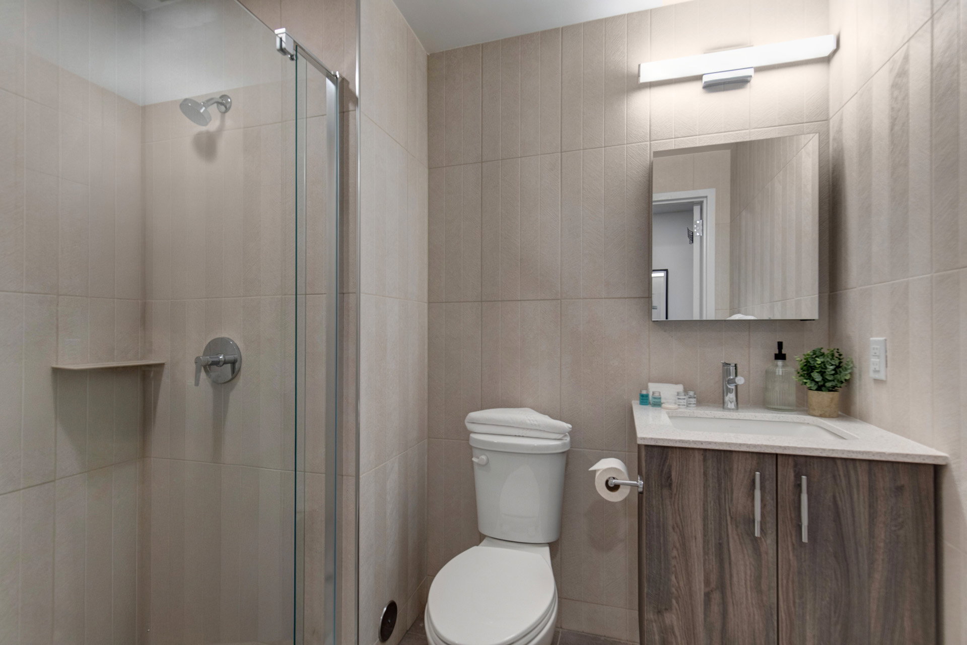 Full bathroom featuring vanity, a shower stall, and tile walls