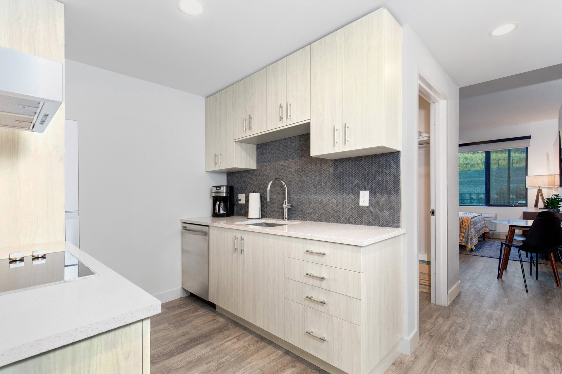 Kitchen featuring light stone countertops, light wood finished floors, black electric cooktop, light wood finish cabinets, and recessed lighting