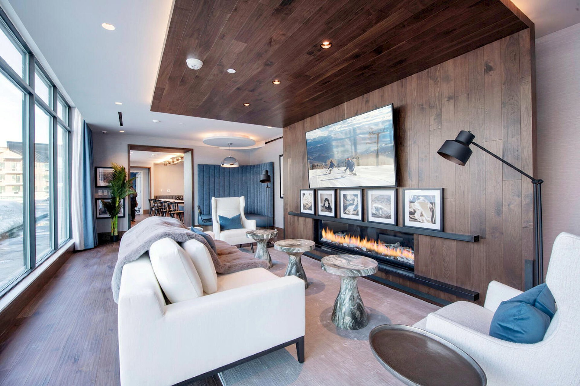 Living room featuring wood finished floors, a glass covered fireplace, wooden walls, and recessed lighting