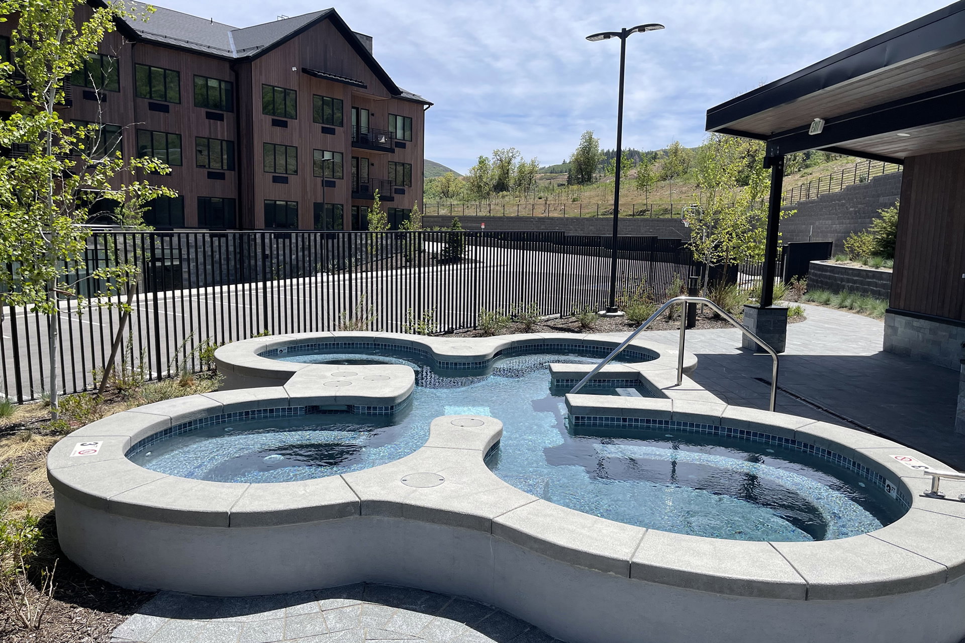 View of pool featuring an in-ground hot tub, a fenced backyard, and patio surround