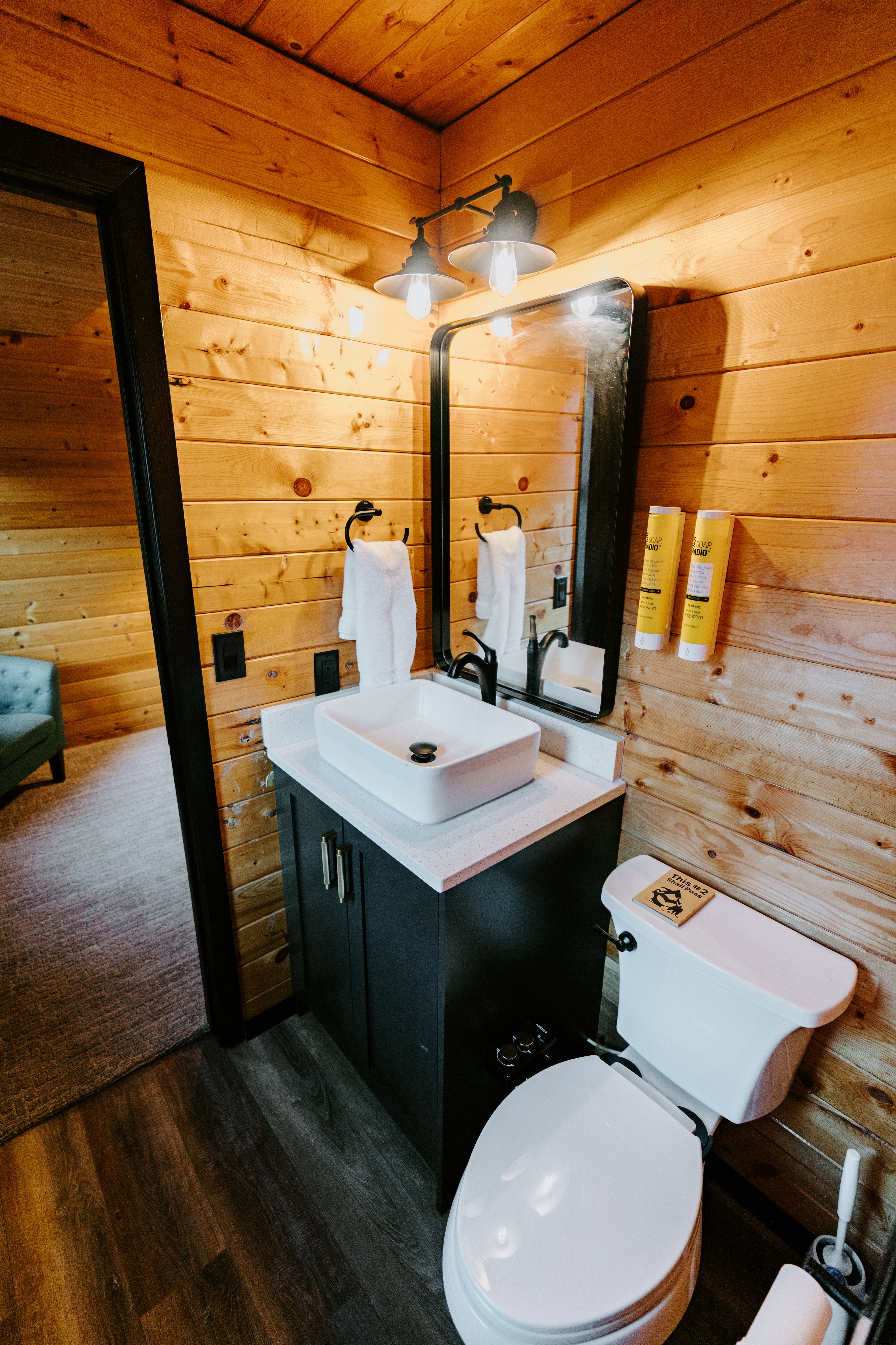 Half bath with wooden walls, vanity, wooden ceiling, and dark wood-style flooring
