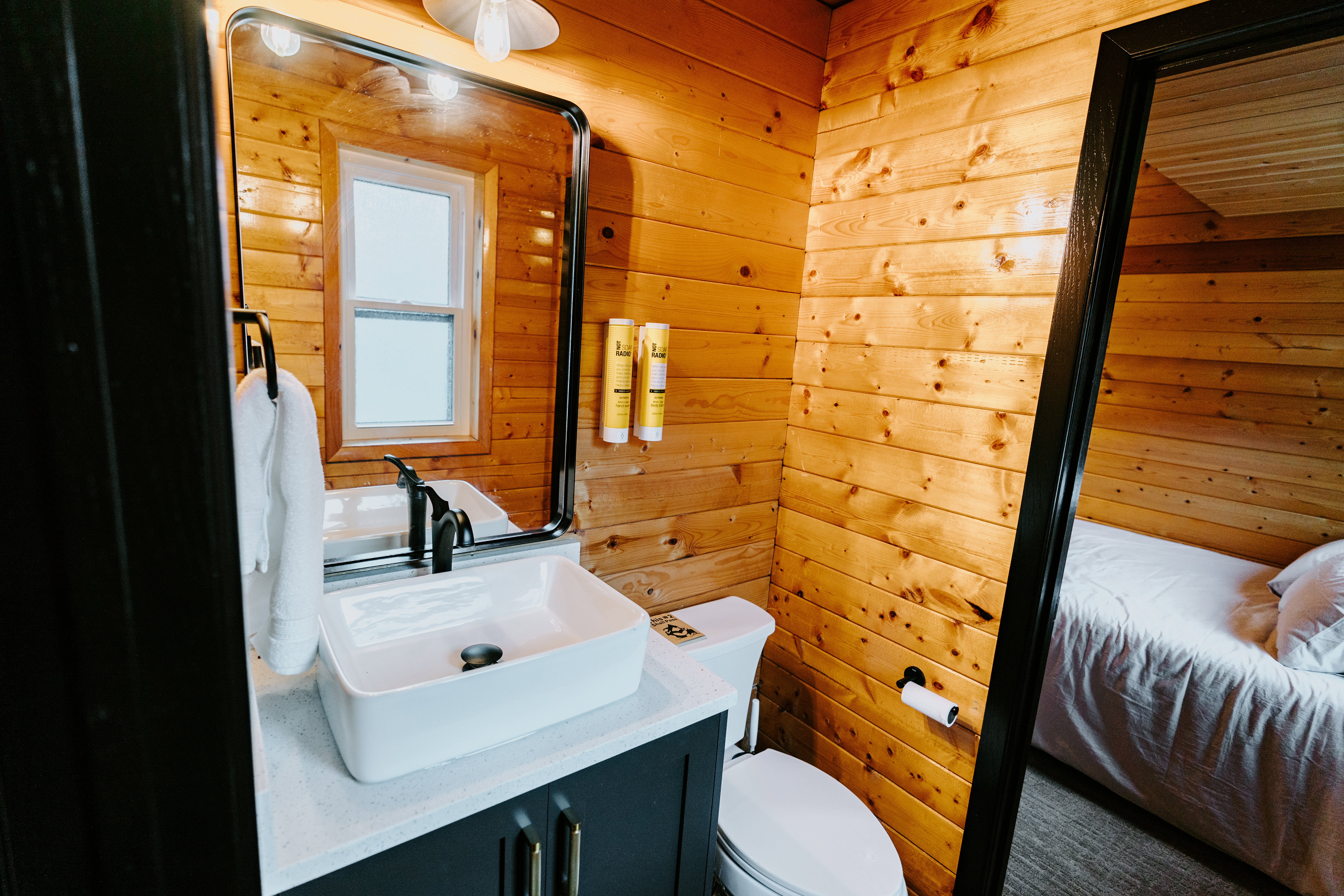 Bathroom with wooden walls, vanity, and ensuite bathroom