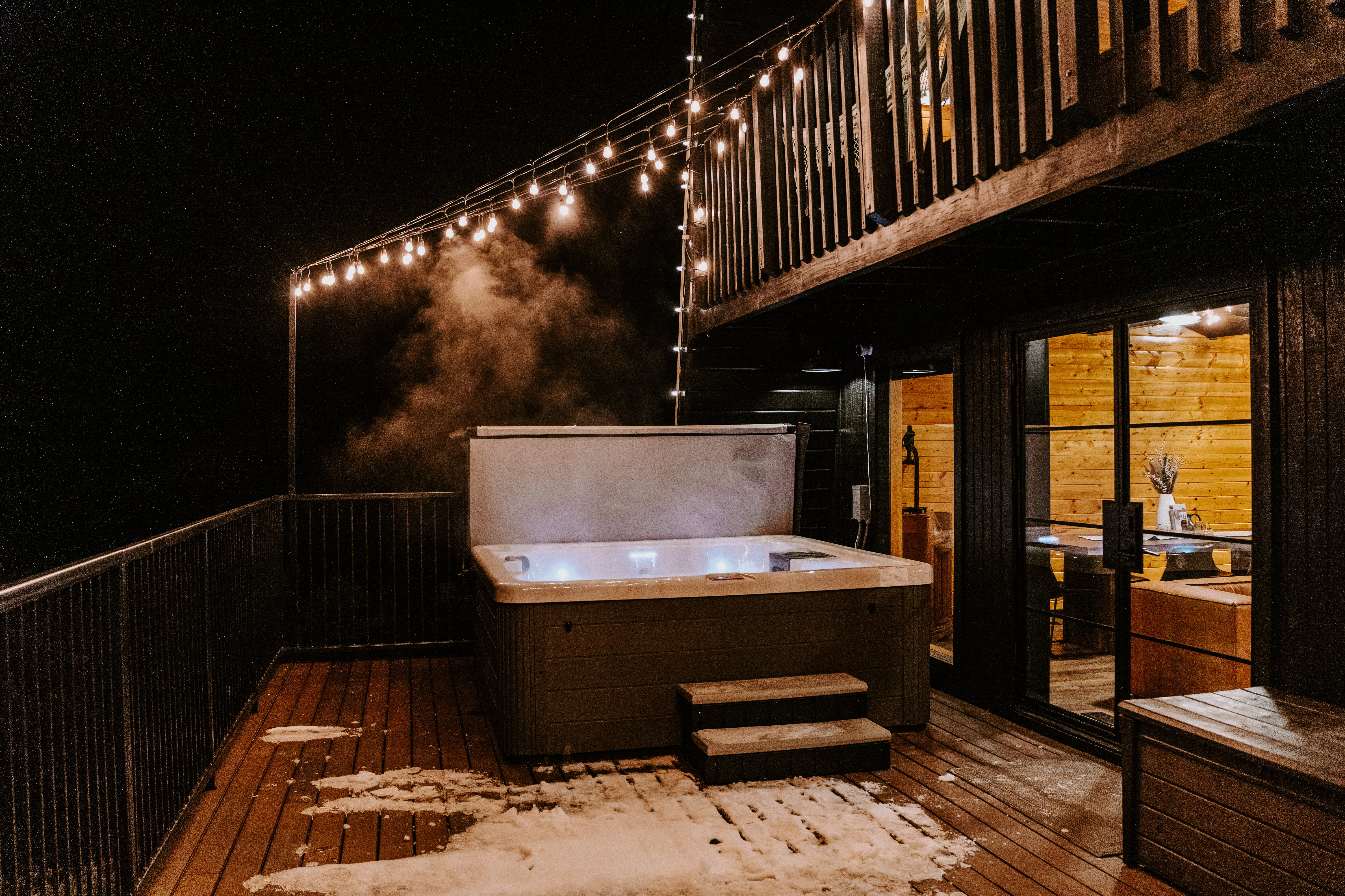 Deck at twilight featuring a hot tub