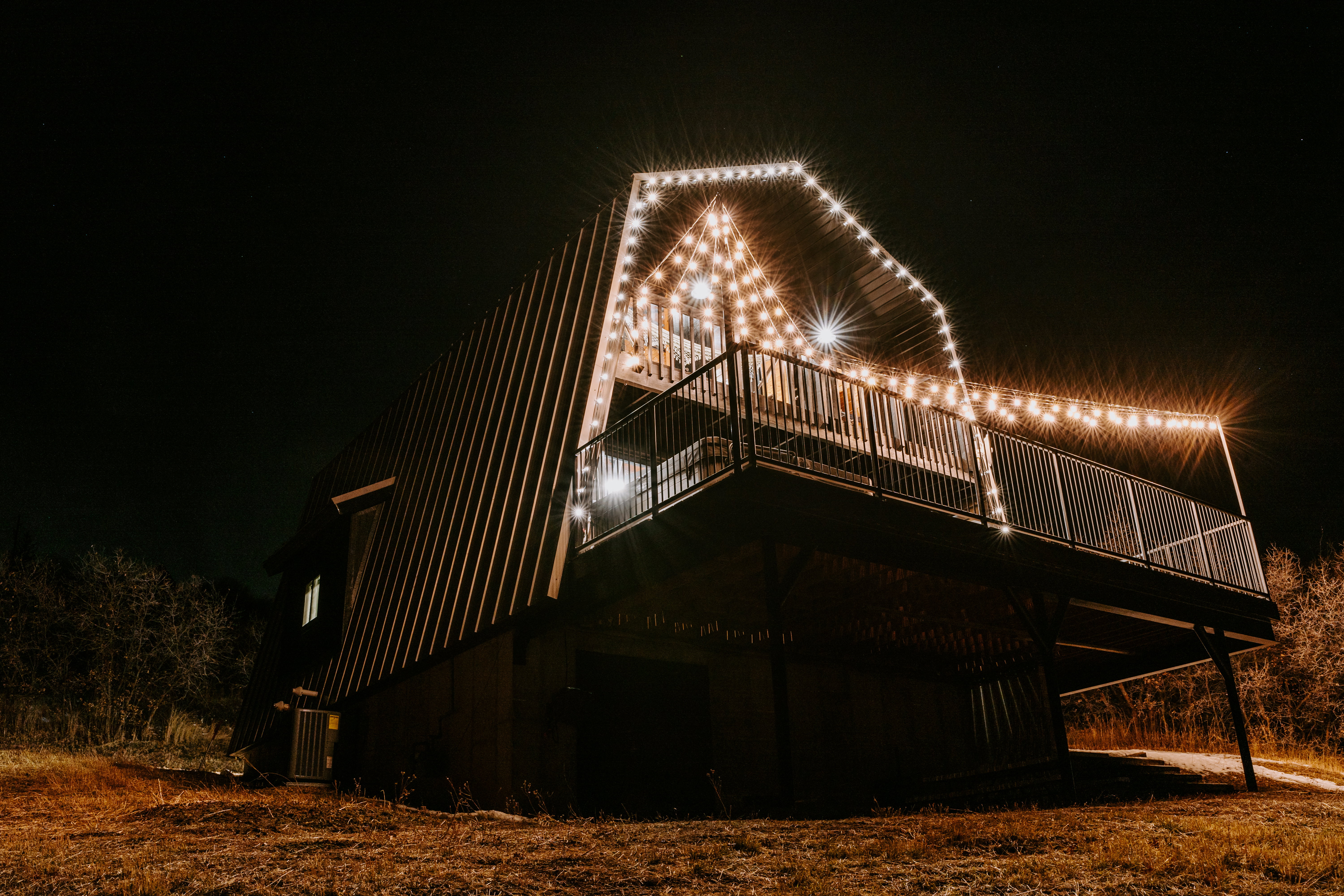 Back of house at night featuring a deck