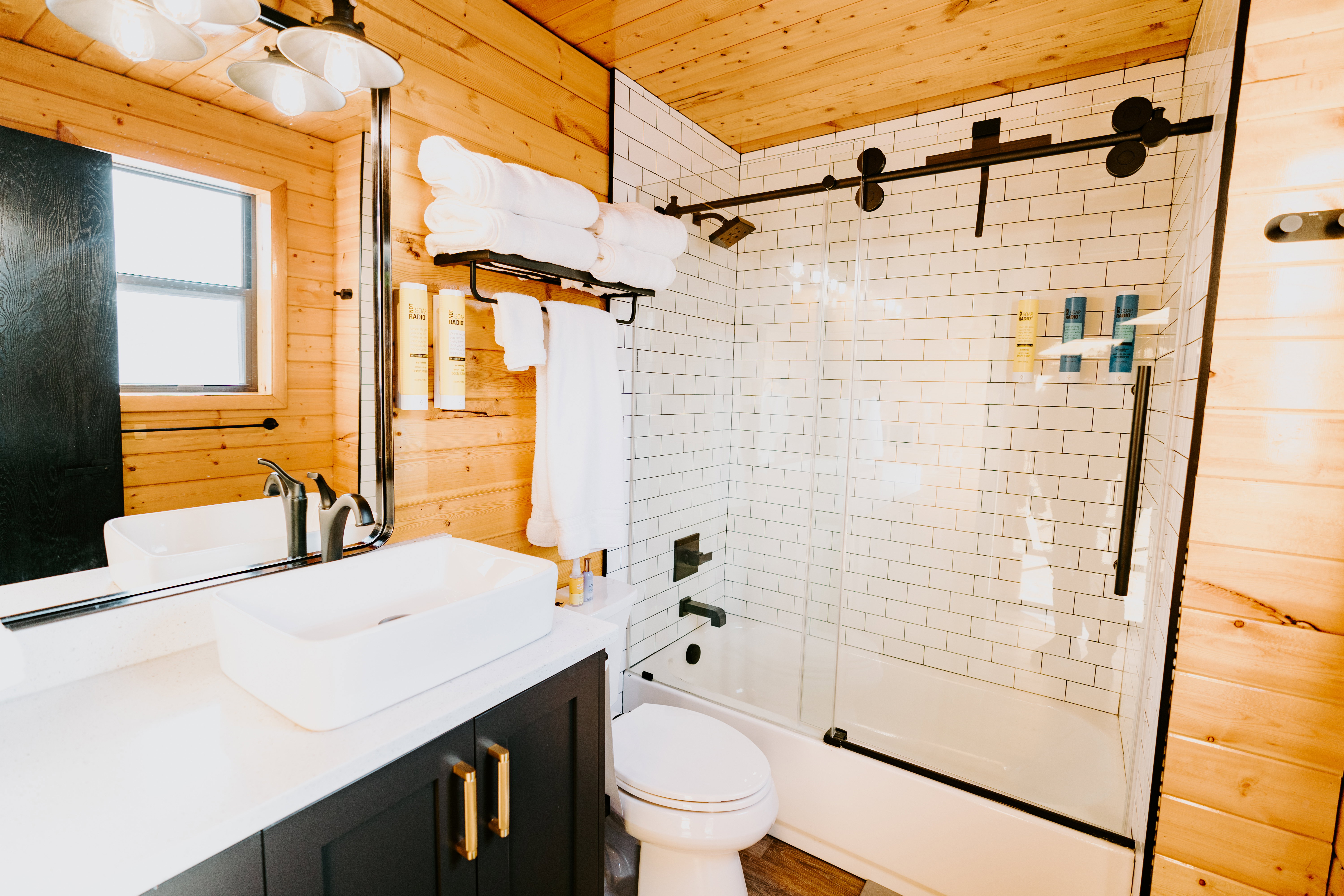 Full bath featuring wooden walls, enclosed tub / shower combo, vanity, and wood ceiling