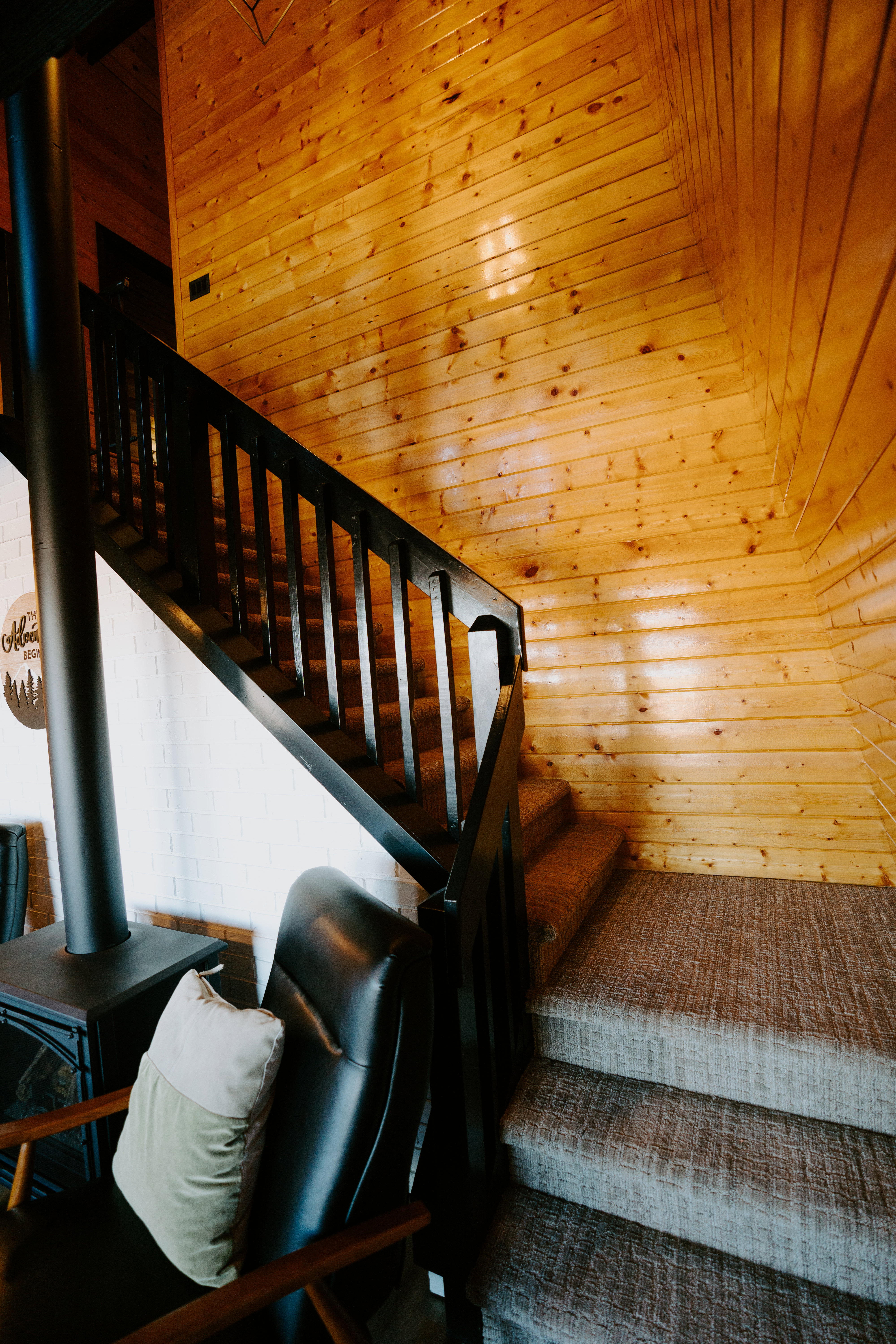 Stairs with a wood stove and wooden ceiling