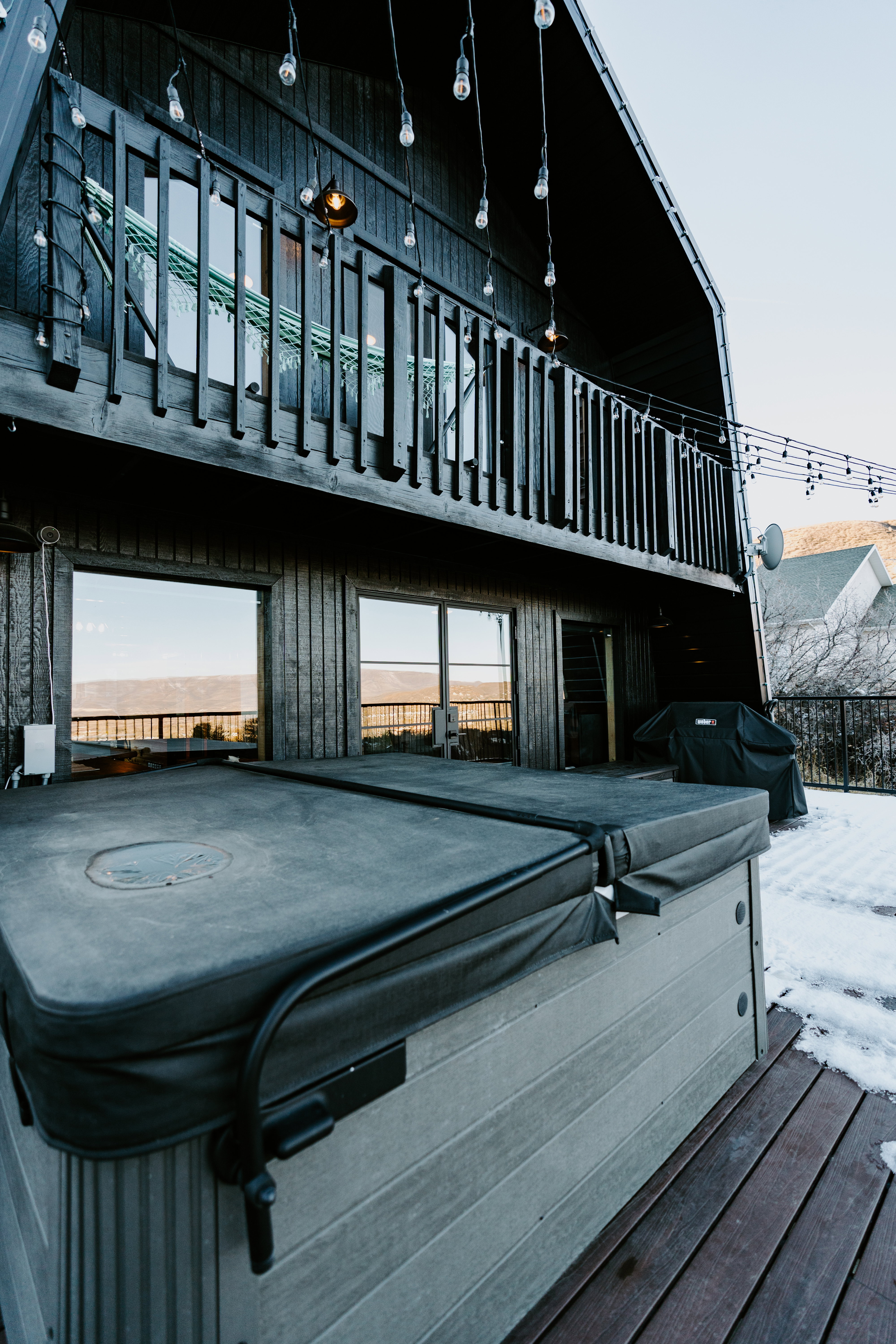 Exterior space with a hot tub and a grill