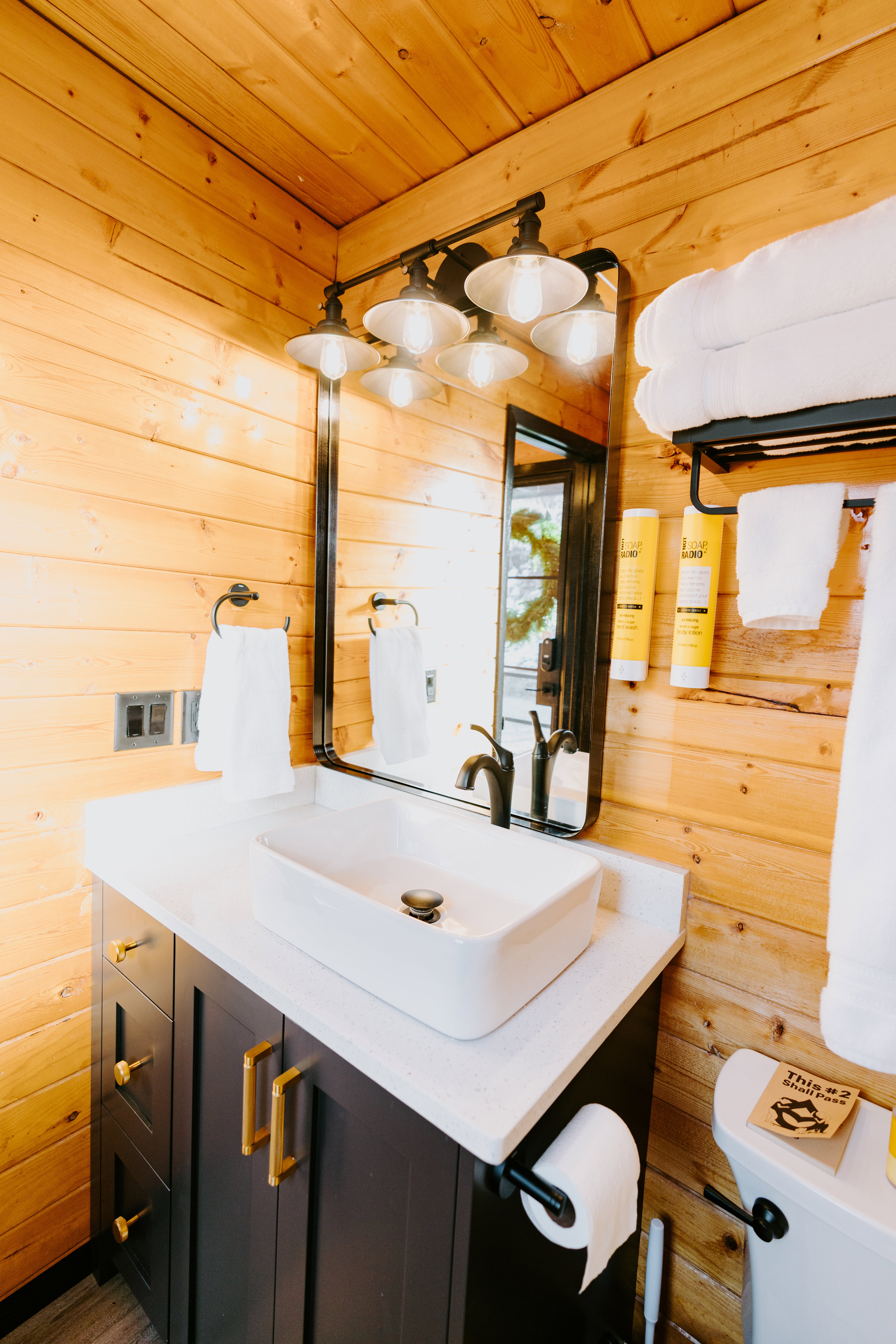 Half bathroom featuring wood walls, vanity, and wood ceiling