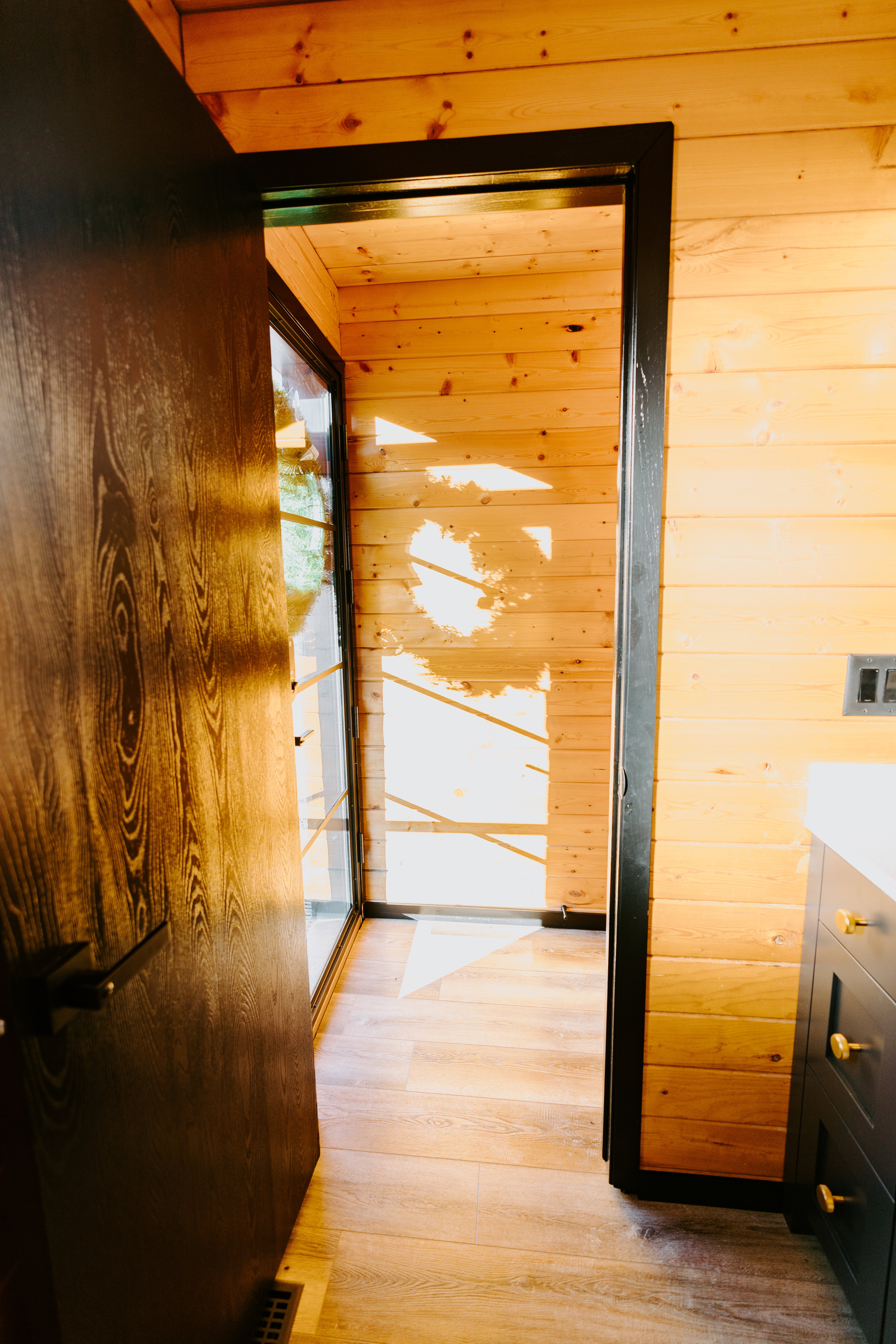 Corridor featuring wooden walls and light wood-style floors
