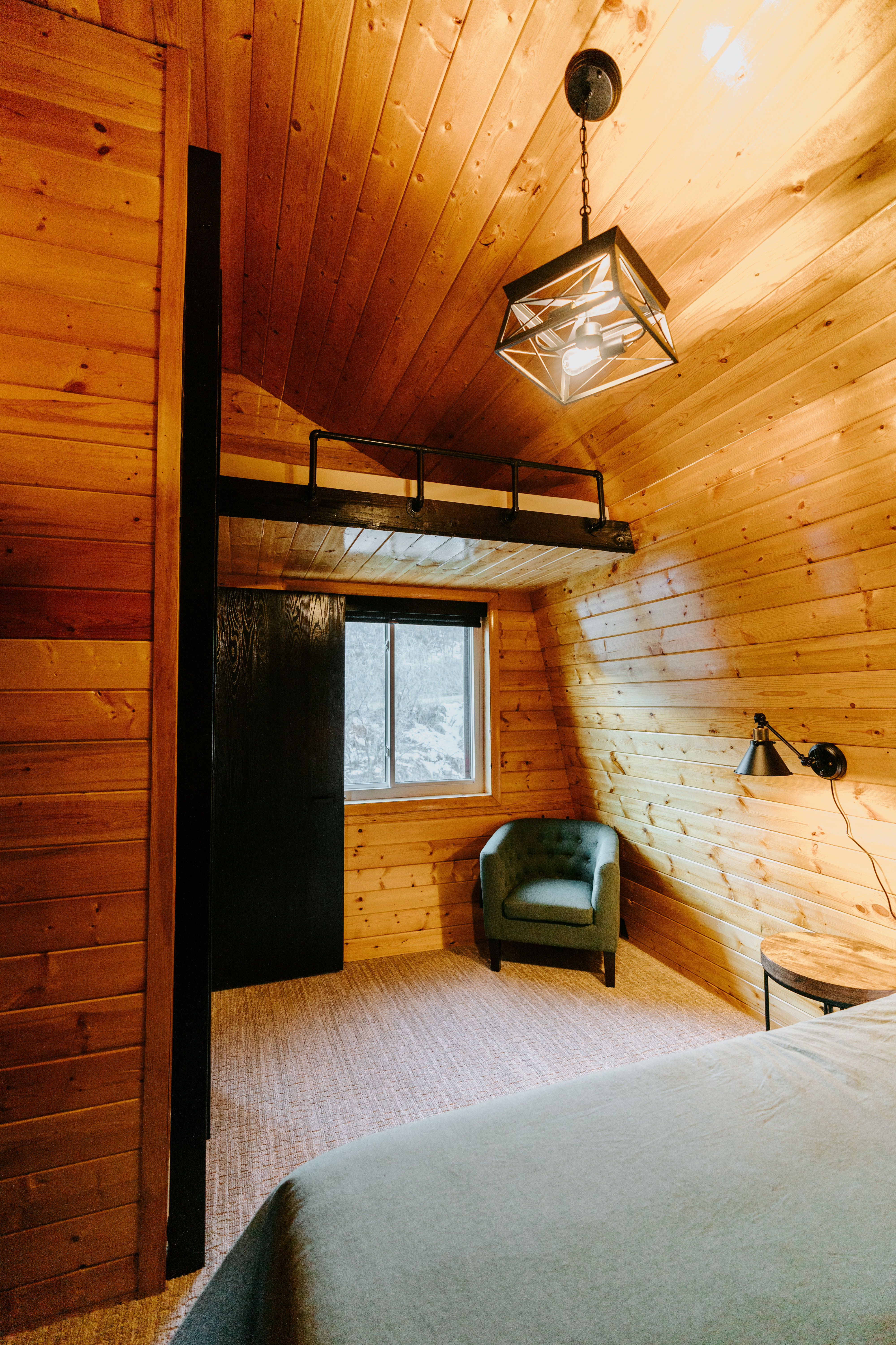 Carpeted bedroom with wood walls and a vaulted wood ceiling