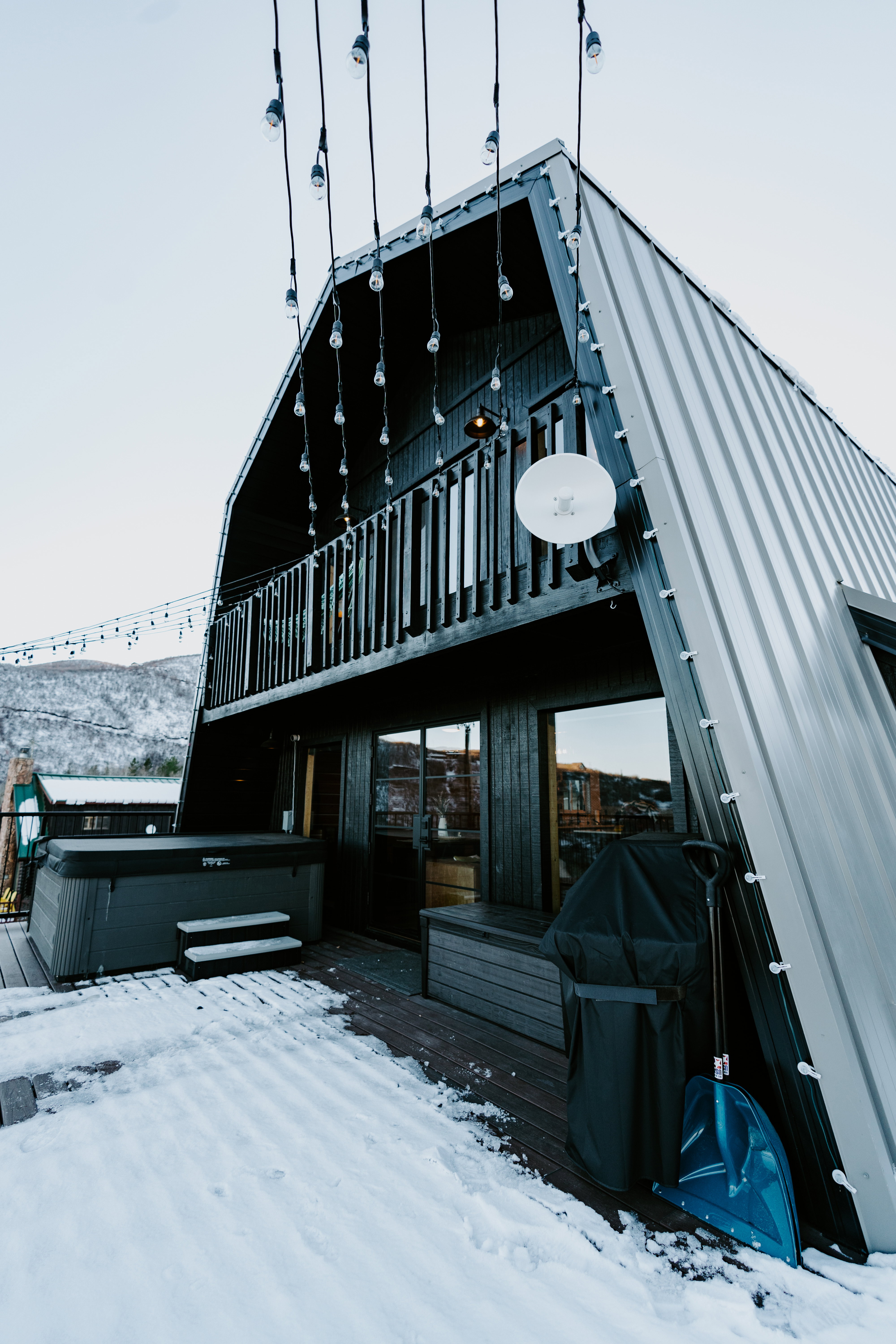 Snow covered house with a gambrel roof and a metal roof