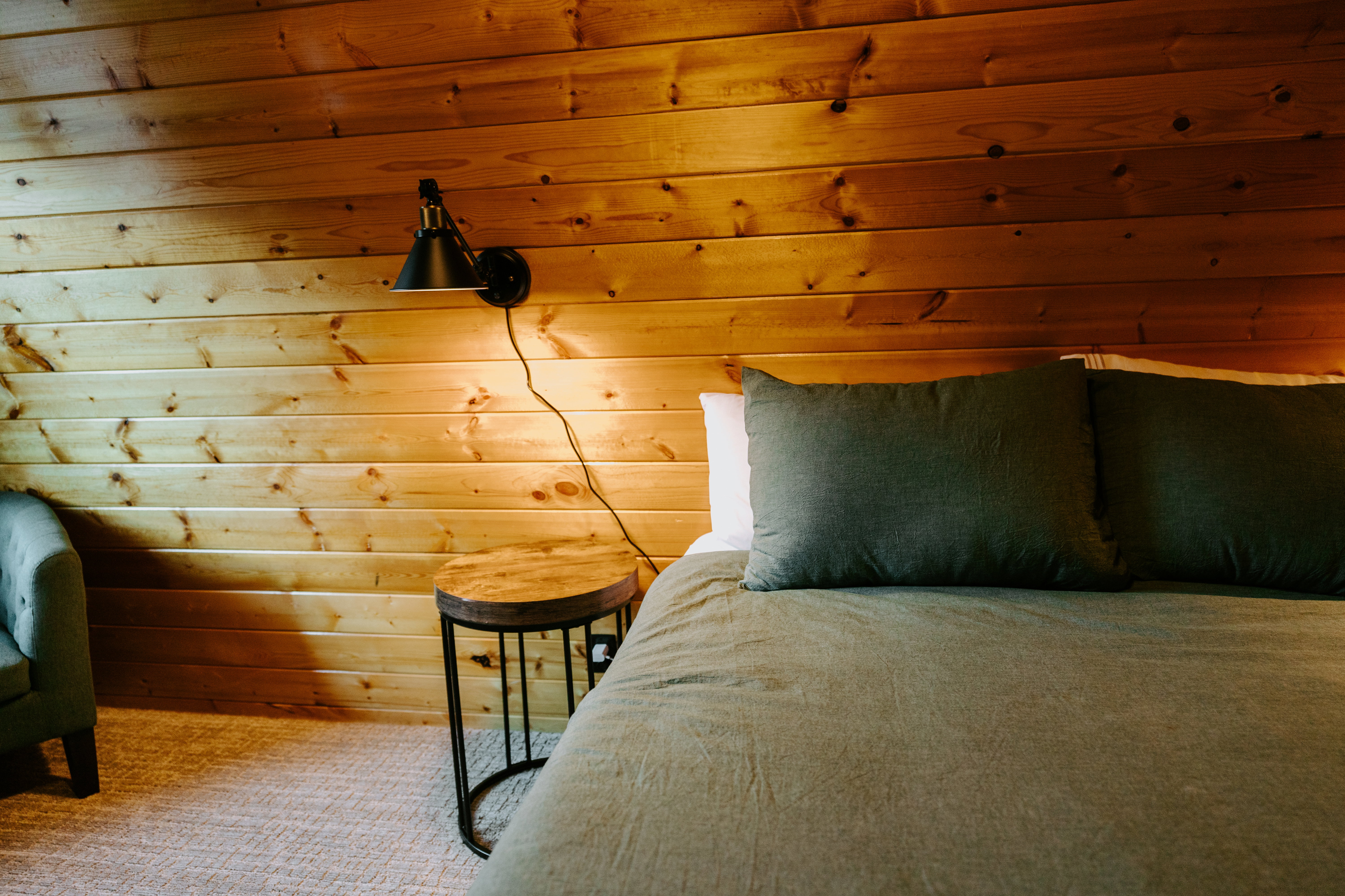 Carpeted bedroom featuring wooden walls