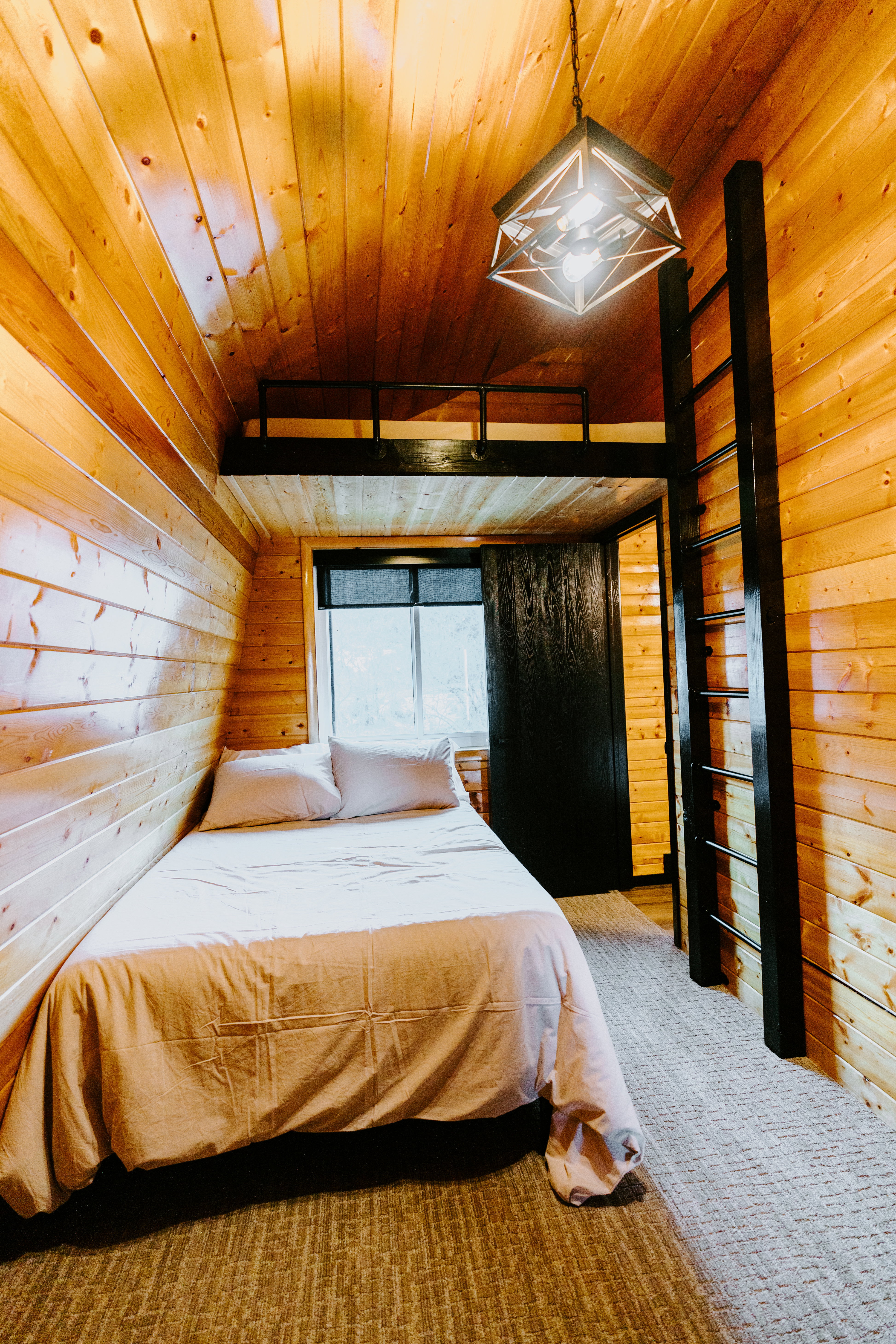 Bedroom featuring wood walls, a vaulted wooden ceiling, and carpet flooring