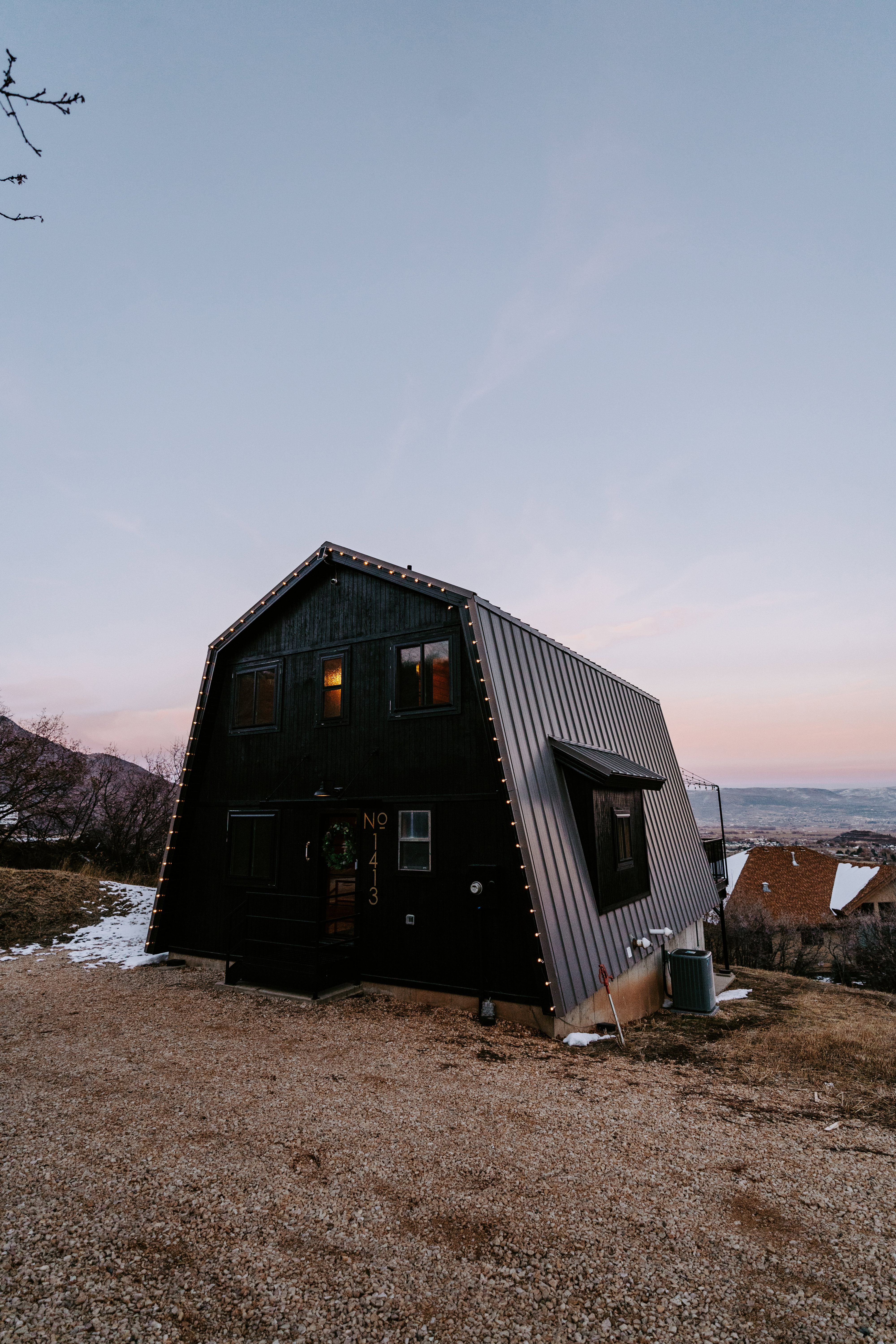 View of front of home with a gambrel roof and a metal roof