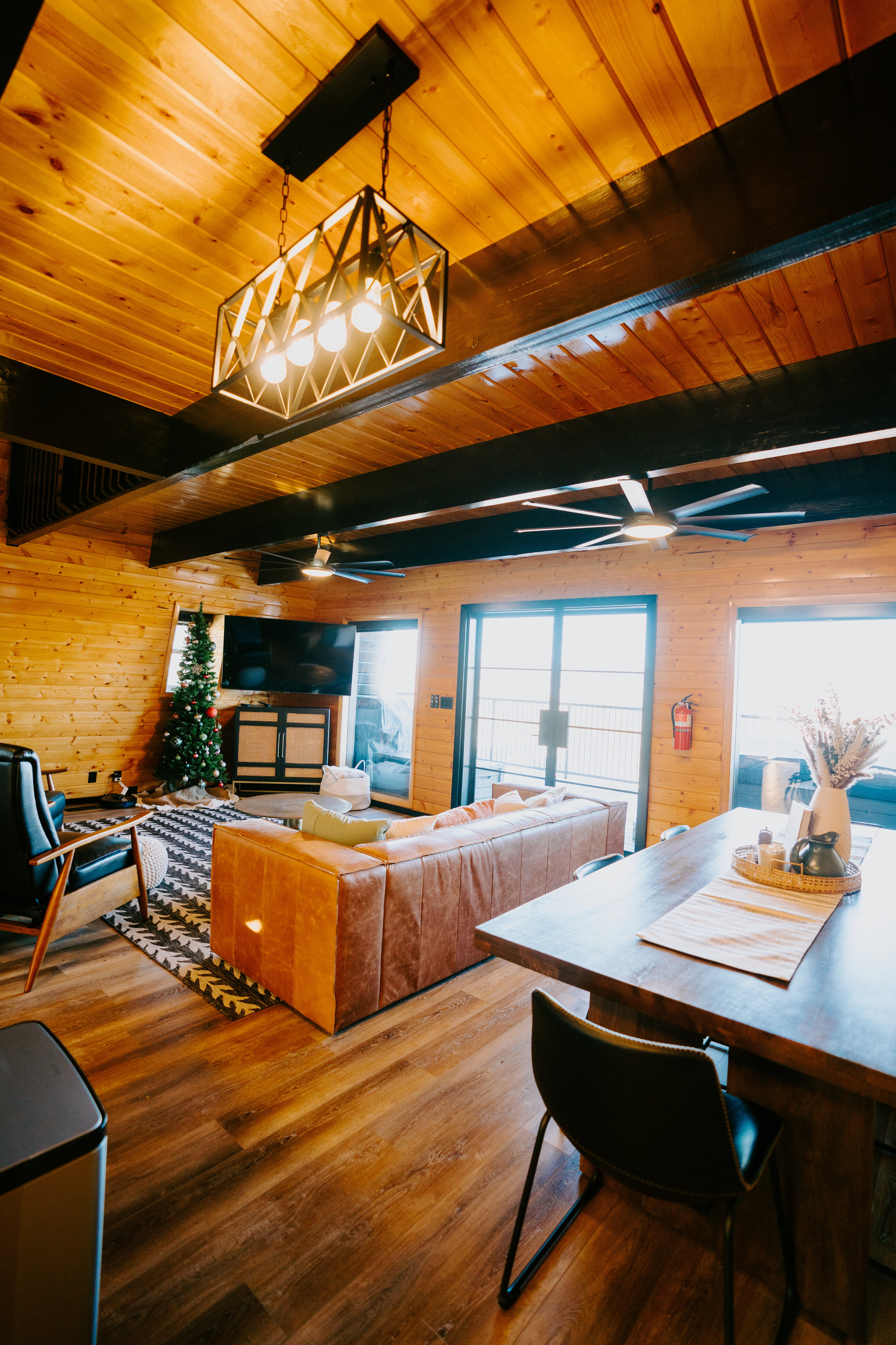 Dining area featuring wooden walls, wood-type flooring, a wood ceiling with exposed beams, and ceiling fan