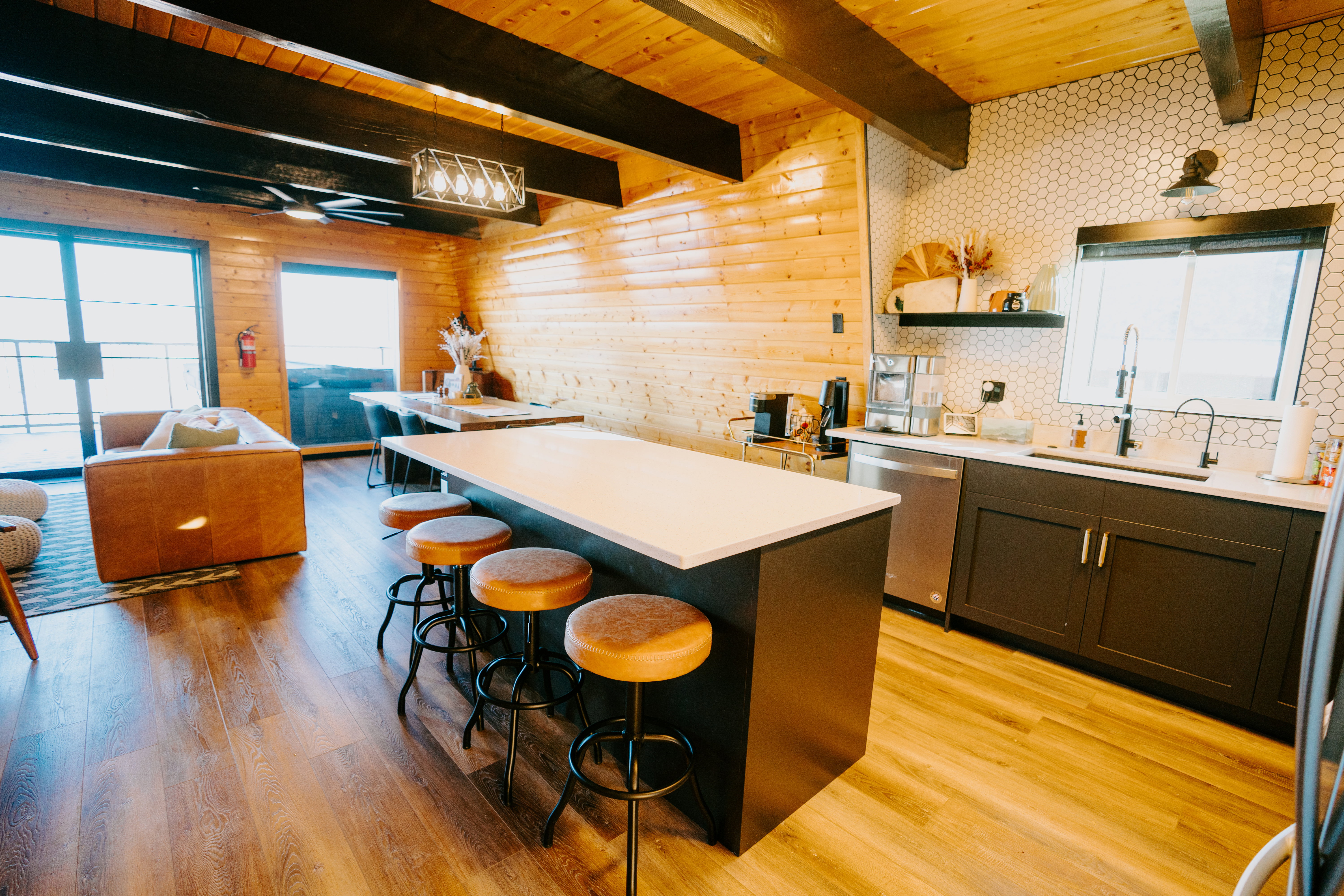 Kitchen featuring healthy amount of natural light, a wood ceiling with exposed beams, a center island, light wood-type flooring, and open floor plan