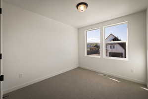 Unfurnished room featuring dark carpet and a textured ceiling