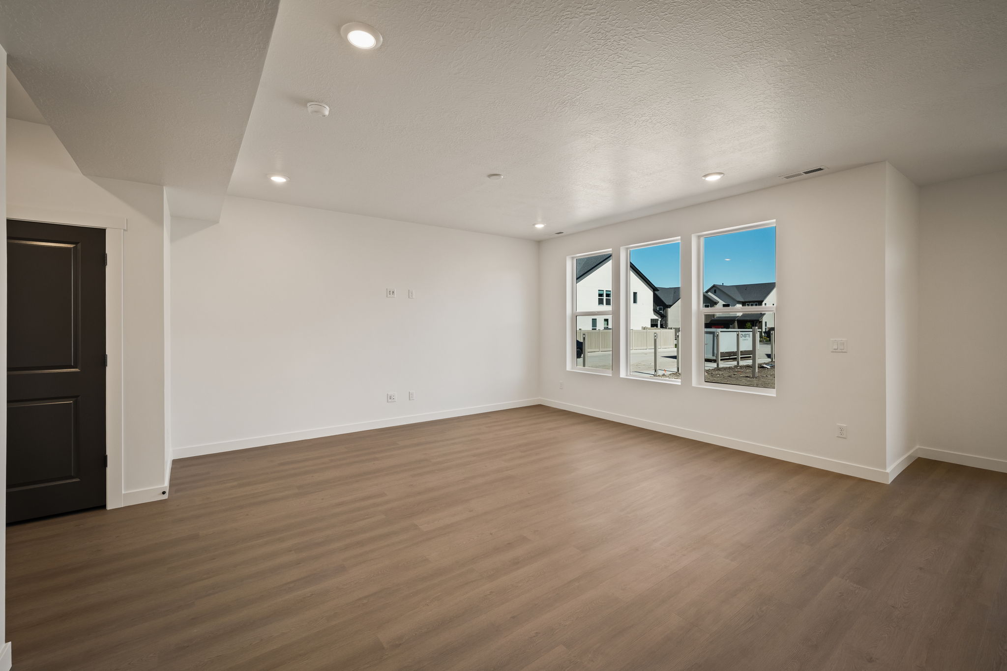 Empty room with recessed lighting, dark wood-type flooring, and a textured ceiling