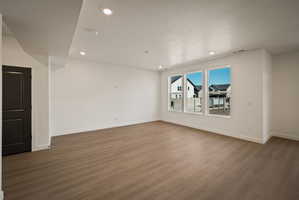 Empty room with recessed lighting, dark wood-type flooring, and a textured ceiling