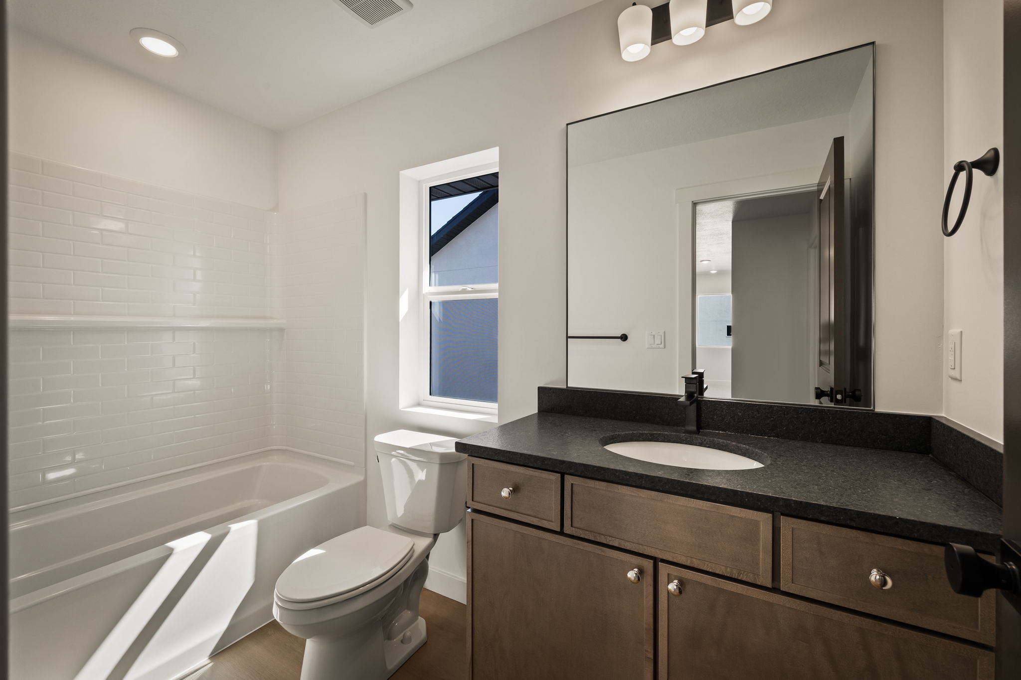 Bathroom featuring vanity, washtub / shower combination, and recessed lighting