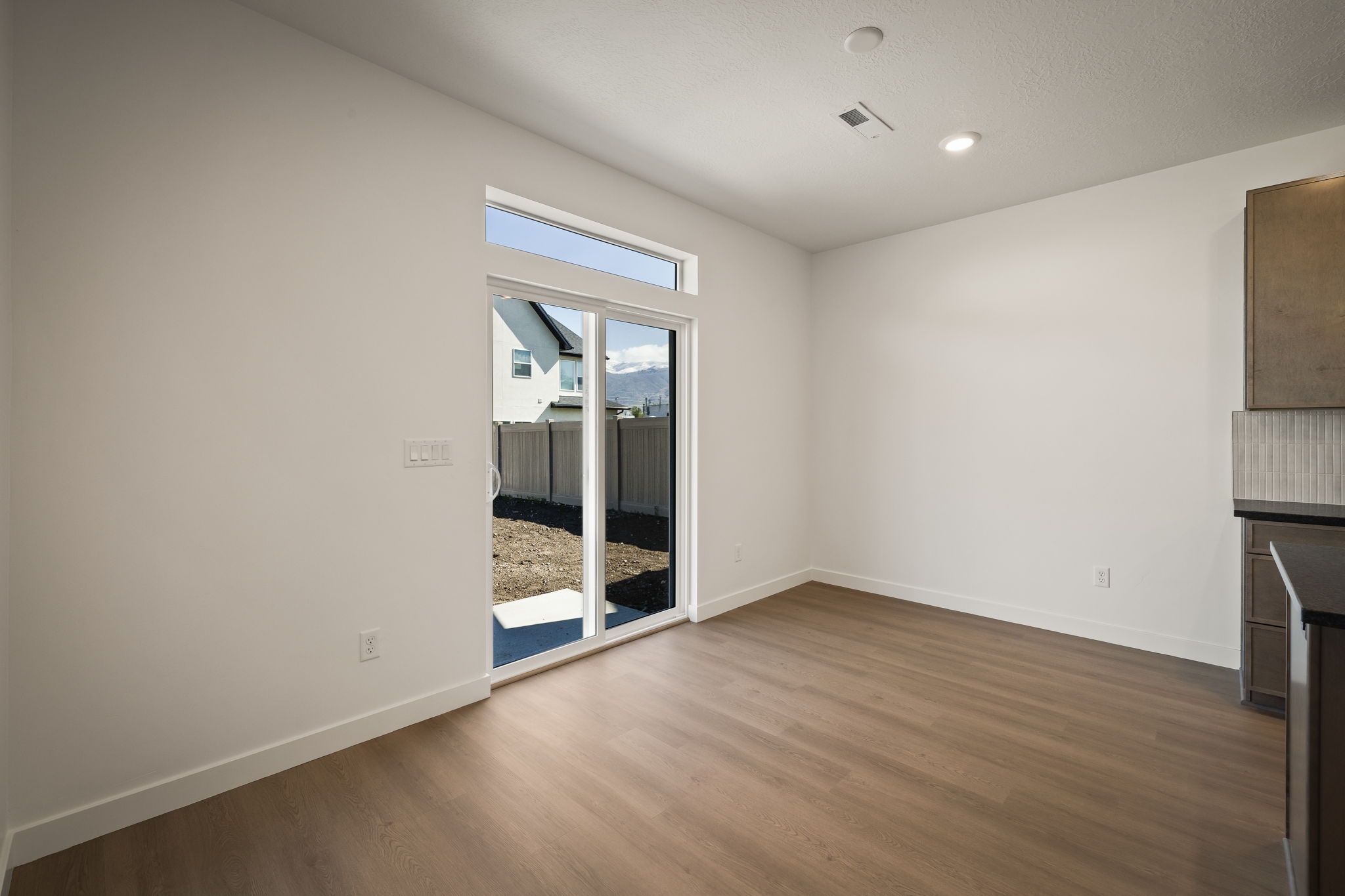 Unfurnished living room featuring dark wood-type flooring and recessed lighting