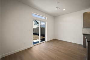 Unfurnished living room featuring dark wood-type flooring and recessed lighting