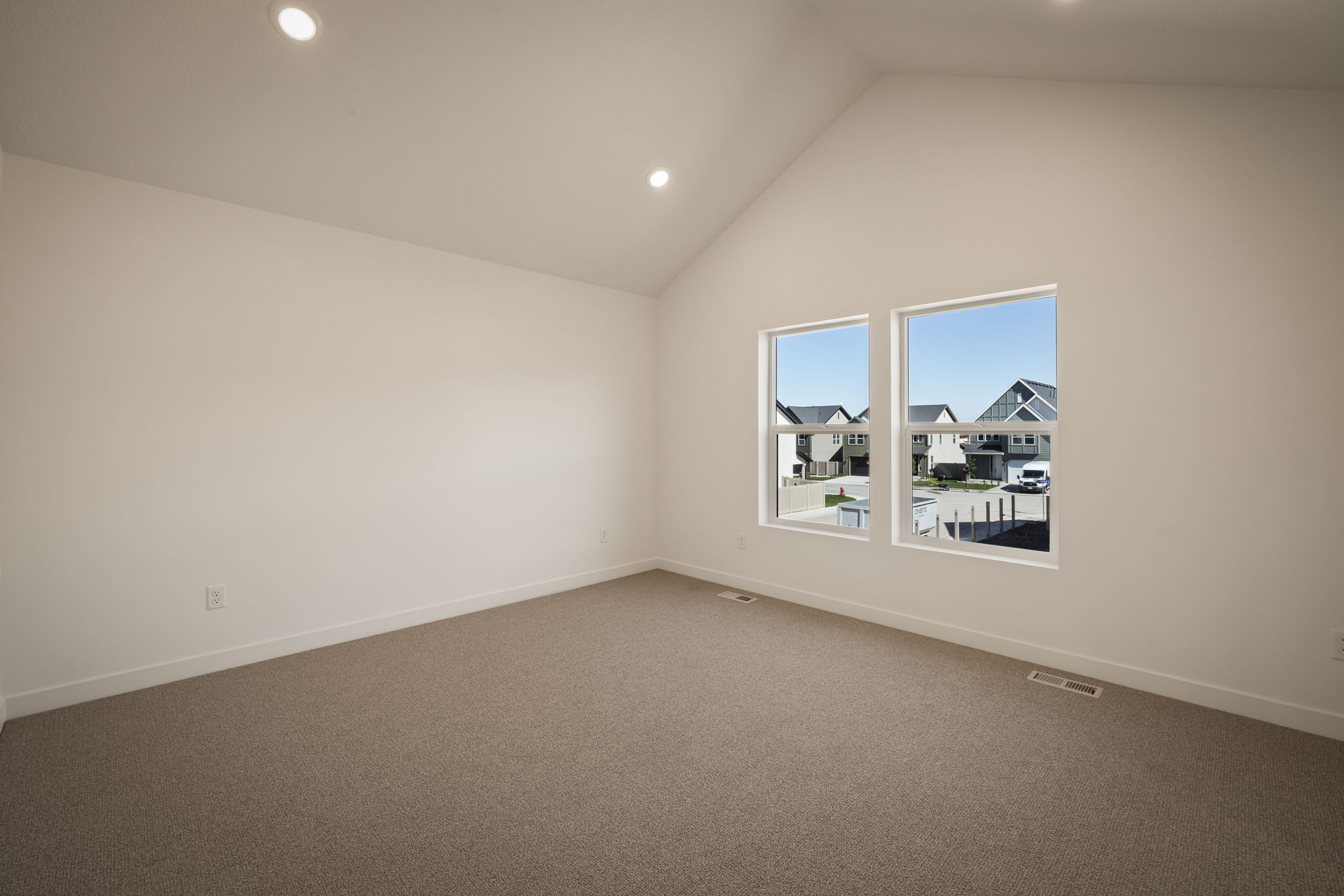Spare room featuring dark colored carpet, a high ceiling, and recessed lighting