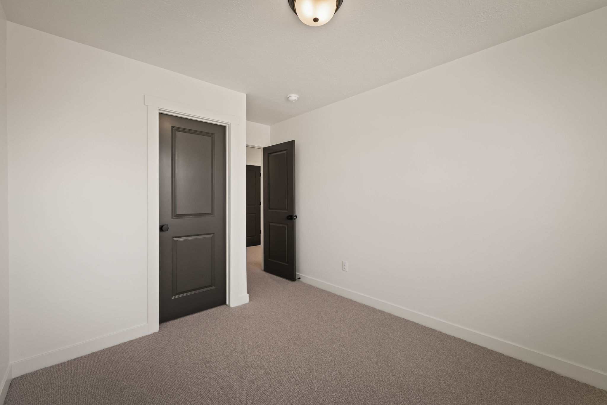 Unfurnished room featuring baseboards and light carpet