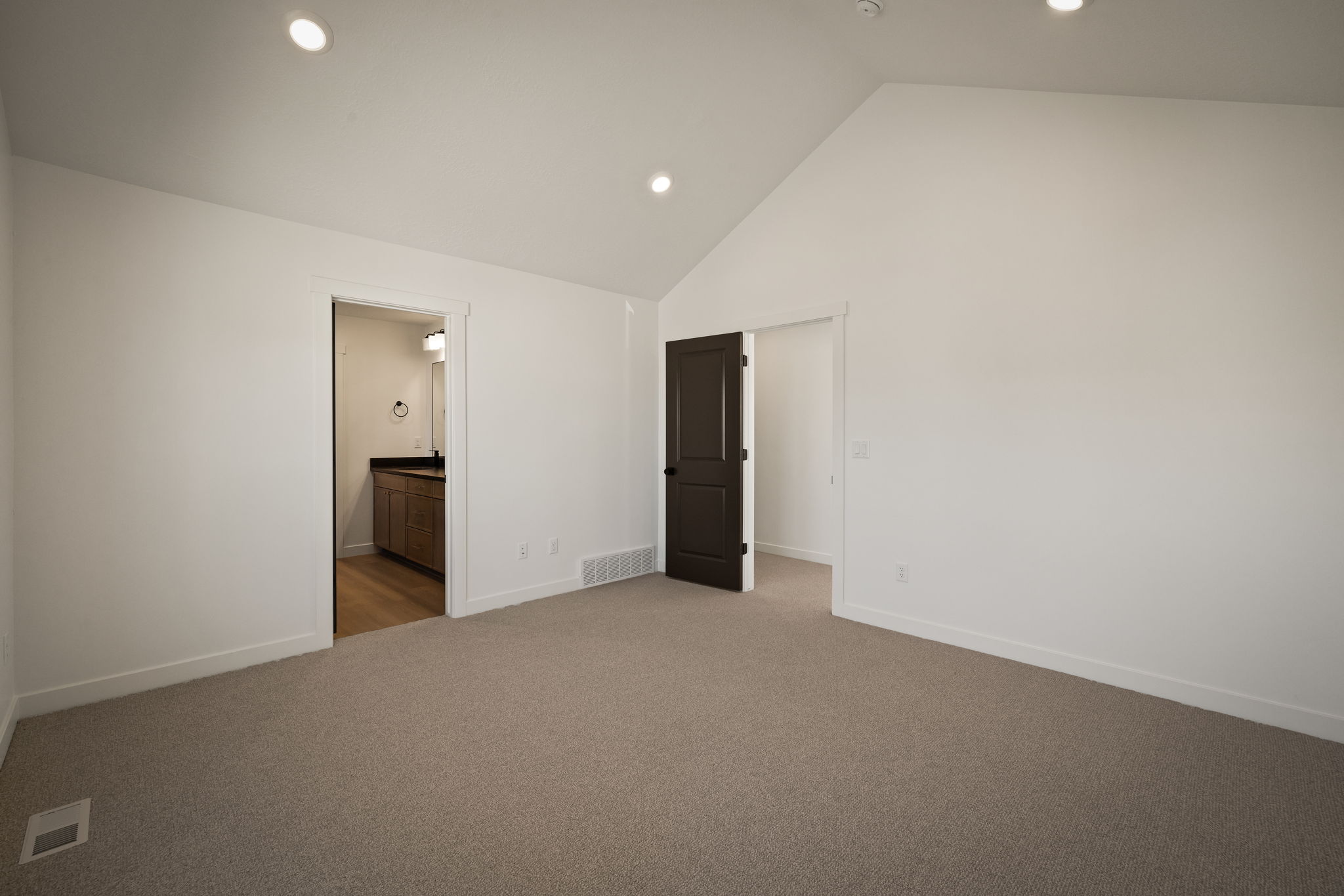 Unfurnished bedroom with carpet, recessed lighting, a high ceiling, and ensuite bathroom