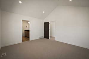 Unfurnished bedroom with carpet, recessed lighting, a high ceiling, and ensuite bathroom