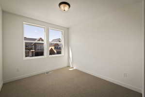 Unfurnished room featuring baseboards and carpet