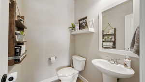 Bathroom near entry featuring toilet and a sink