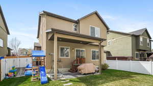 Back of house featuring stucco siding, a fenced backyard, and a patio