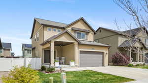 View of front of home with a gate, stucco siding, concrete driveway, covered porch, and a garage