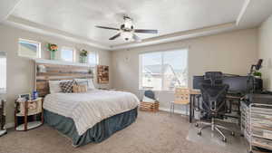 Master Bedroom Carpeted bedroom featuring a raised ceiling, a ceiling fan, an office area, and a textured ceiling