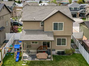Rear view of property featuring a shingled roof, a residential view, a patio, a mountain view, and stucco siding