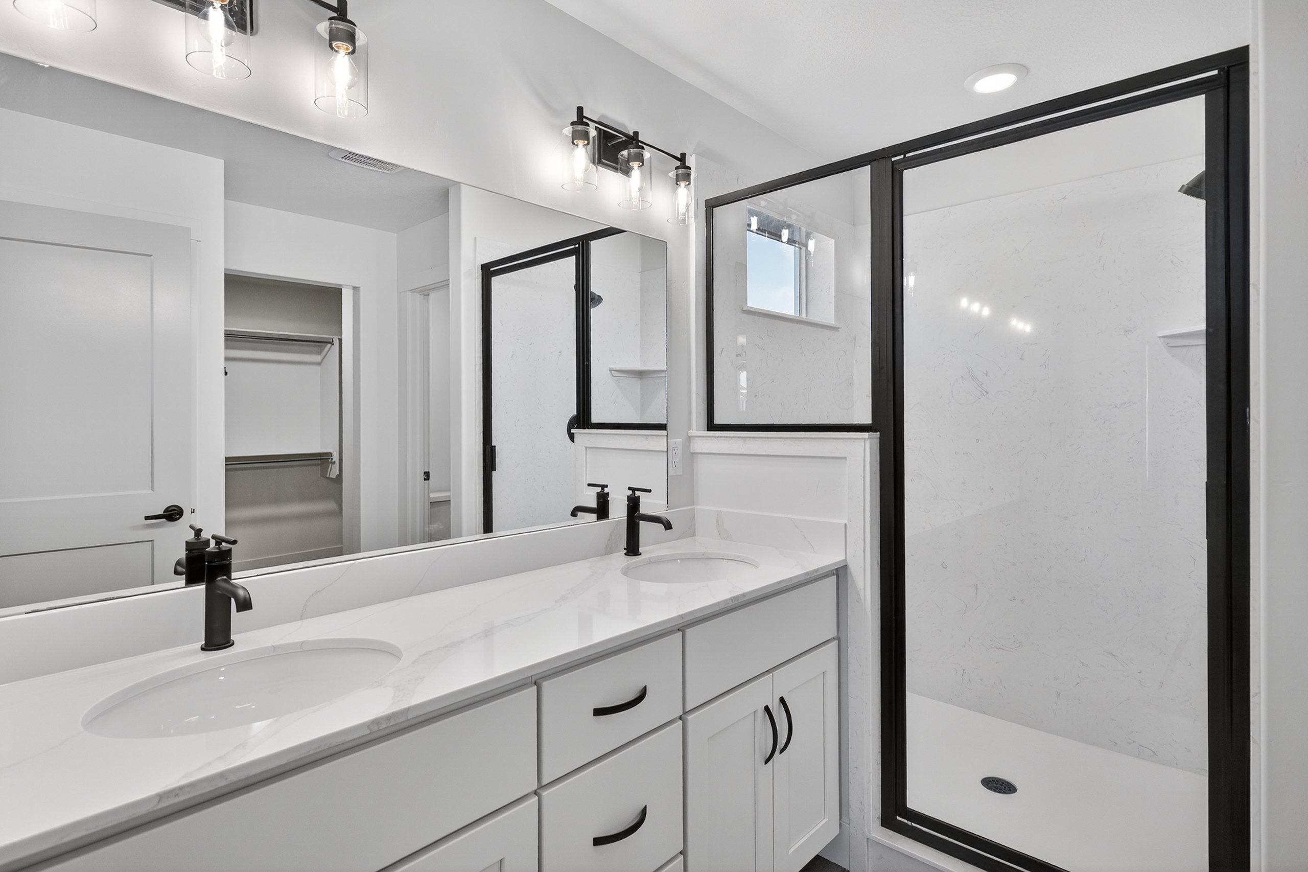Bathroom with a marble finish shower, double vanity, and a spacious closet
