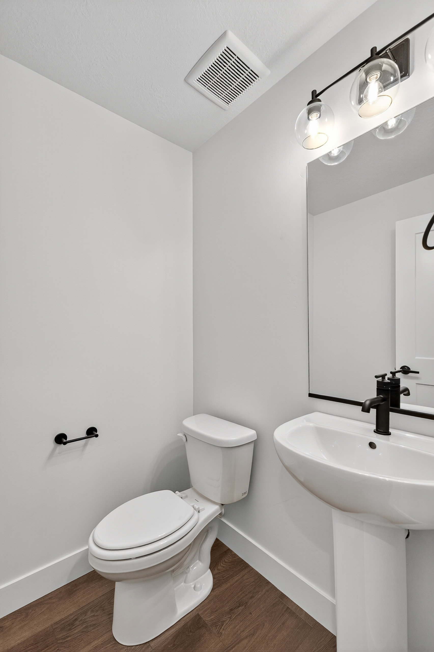 Half bath with toilet and dark wood-style floors