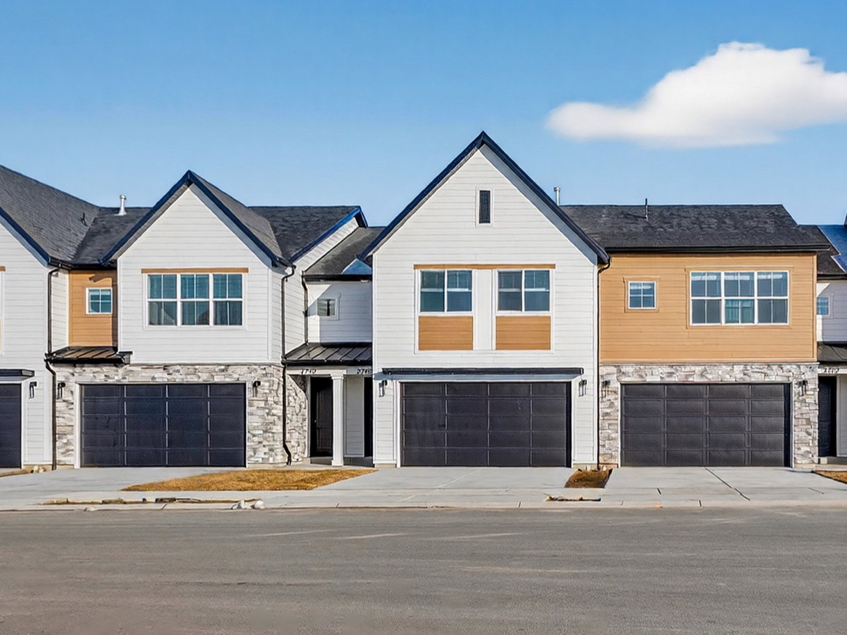View of front of house featuring stone siding, a residential view, and an attached garage