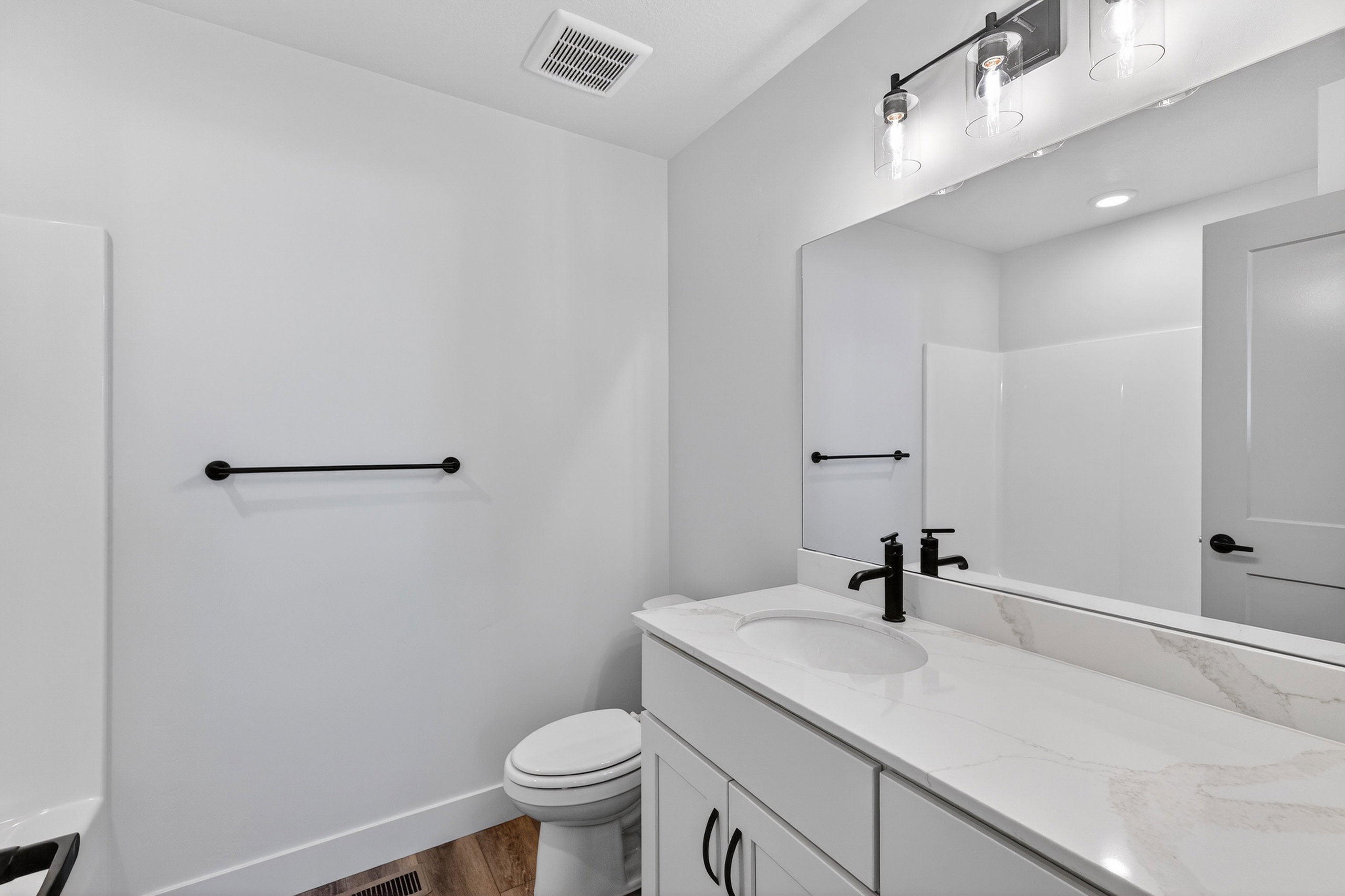 Full bathroom with vanity and dark wood-style flooring