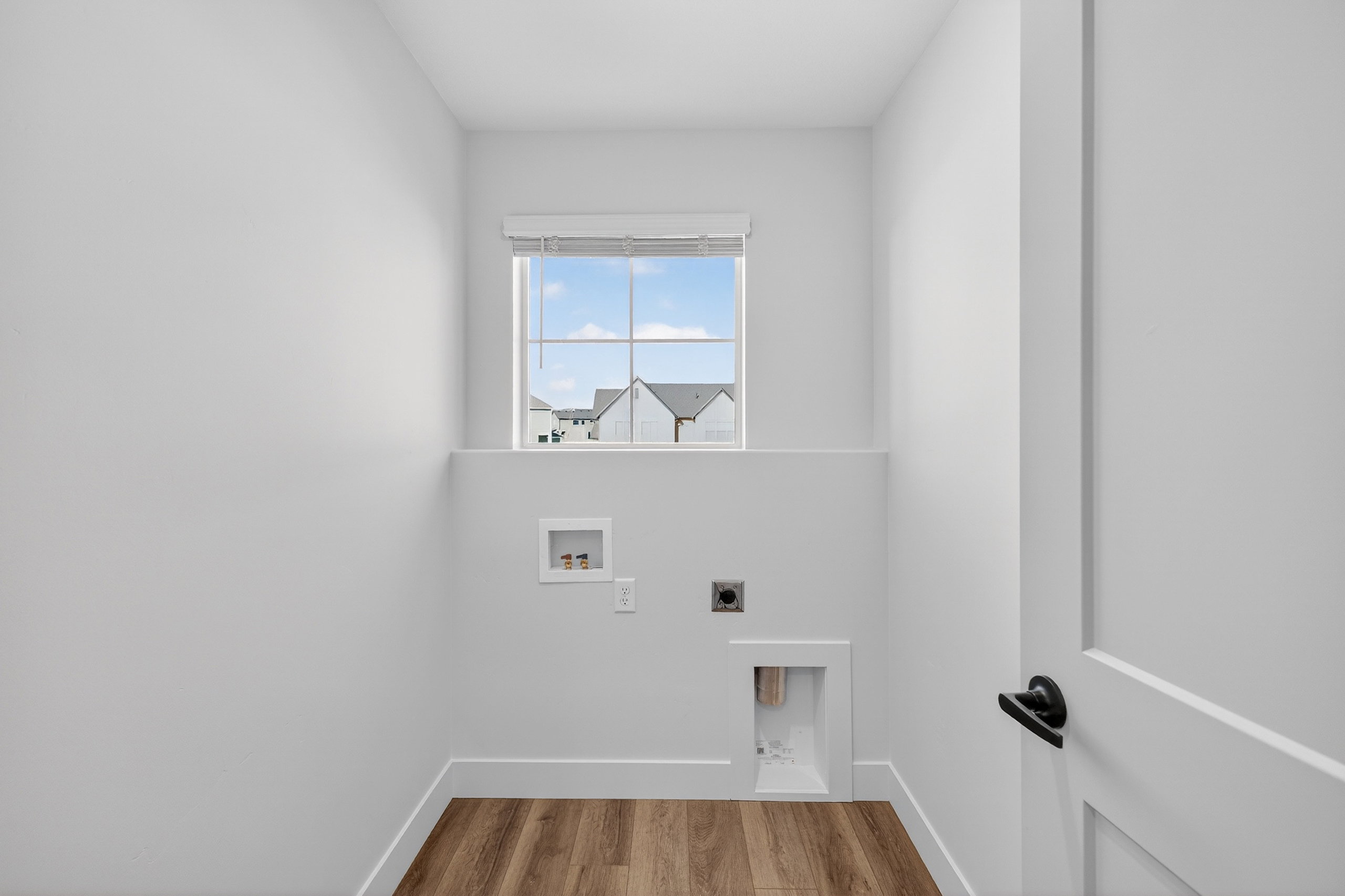 Laundry area with hookup for an electric dryer, light wood finished floors, and washer hookup