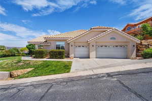 Mediterranean / spanish-style home with stucco siding, an attached garage, driveway, a tiled roof, and a front yard