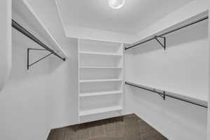 Walk in closet featuring dark carpet