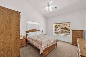 Carpeted bedroom featuring lofted ceiling and ceiling fan