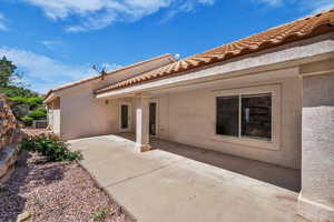 Back of property with stucco siding and a tiled roof