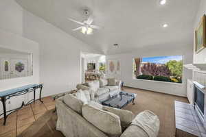 Living area with a ceiling fan, a tile fireplace, and recessed lighting