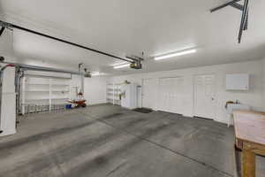 Garage with white fridge with ice dispenser and a sink